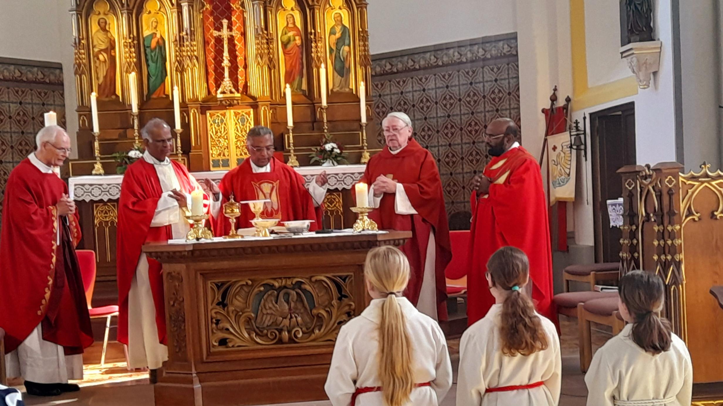 5 Priester am Altar einer Kirche , im Vordergrund 3 Messdienerinnen