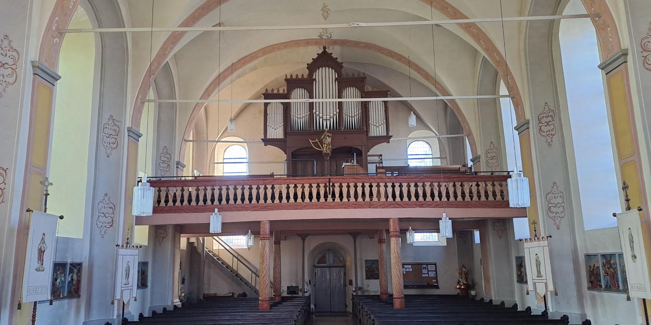 Orgelempore Mörsdorf (c) Christian Jager Blick vom Altarbereich zur Orgelempore der Kirche St. Kastor in Mörsdorf. Die historische Orgel, die Empore und die harmonische Architektur des Kirchenraums stehen im Mittelpunkt der Aufnahme.
