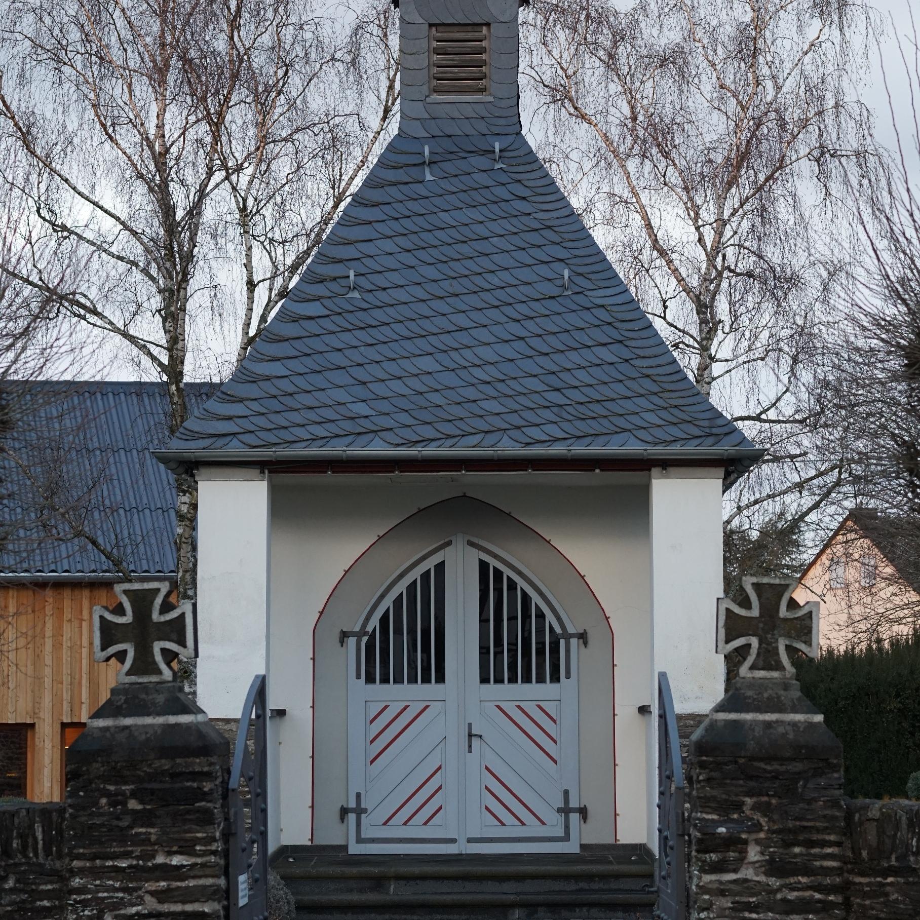 Ein kleines Gebäude mit Dachreiter und weißen Türen.
