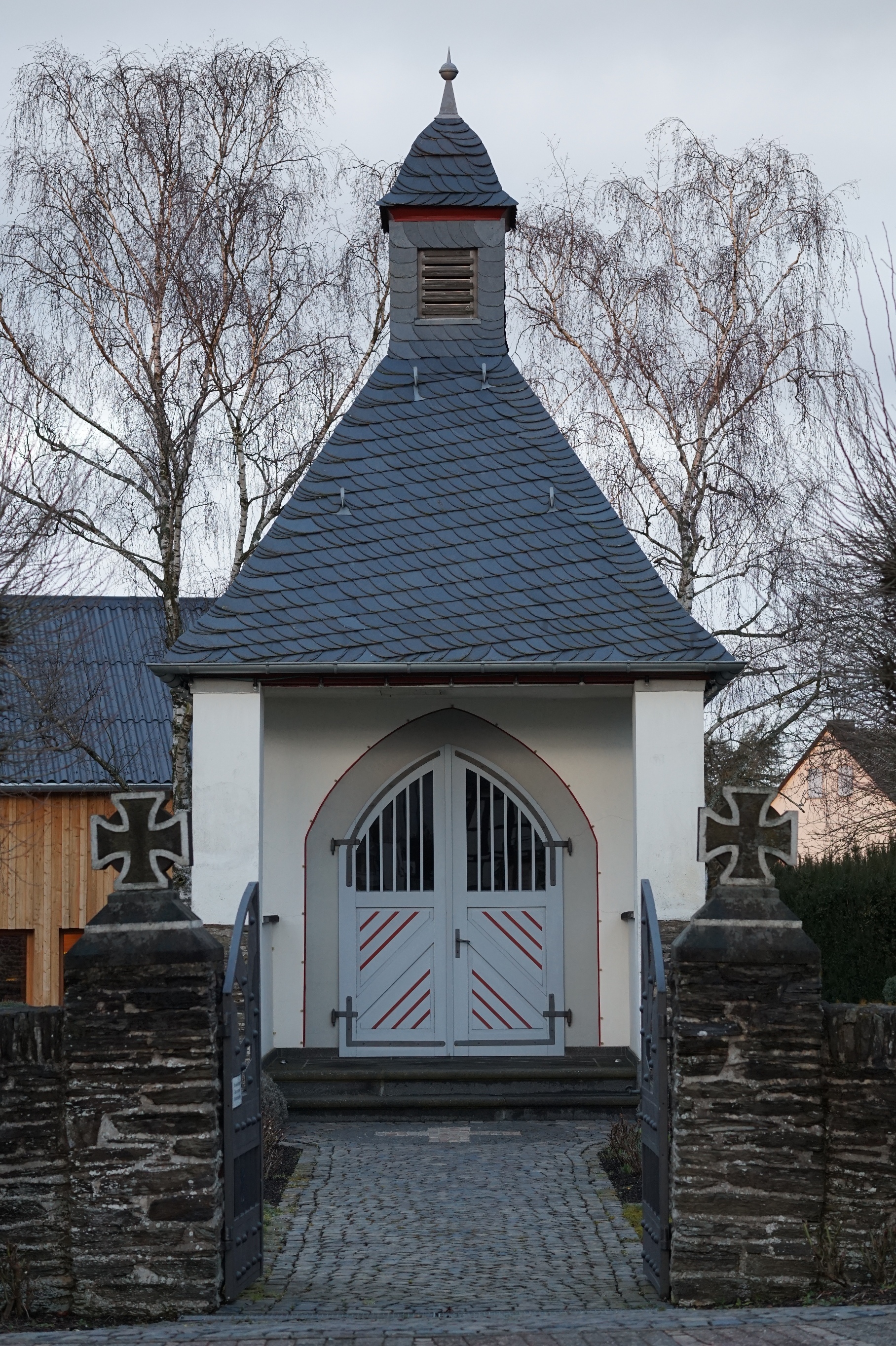 Ein kleines Gebäude mit Dachreiter und weißen Türen.