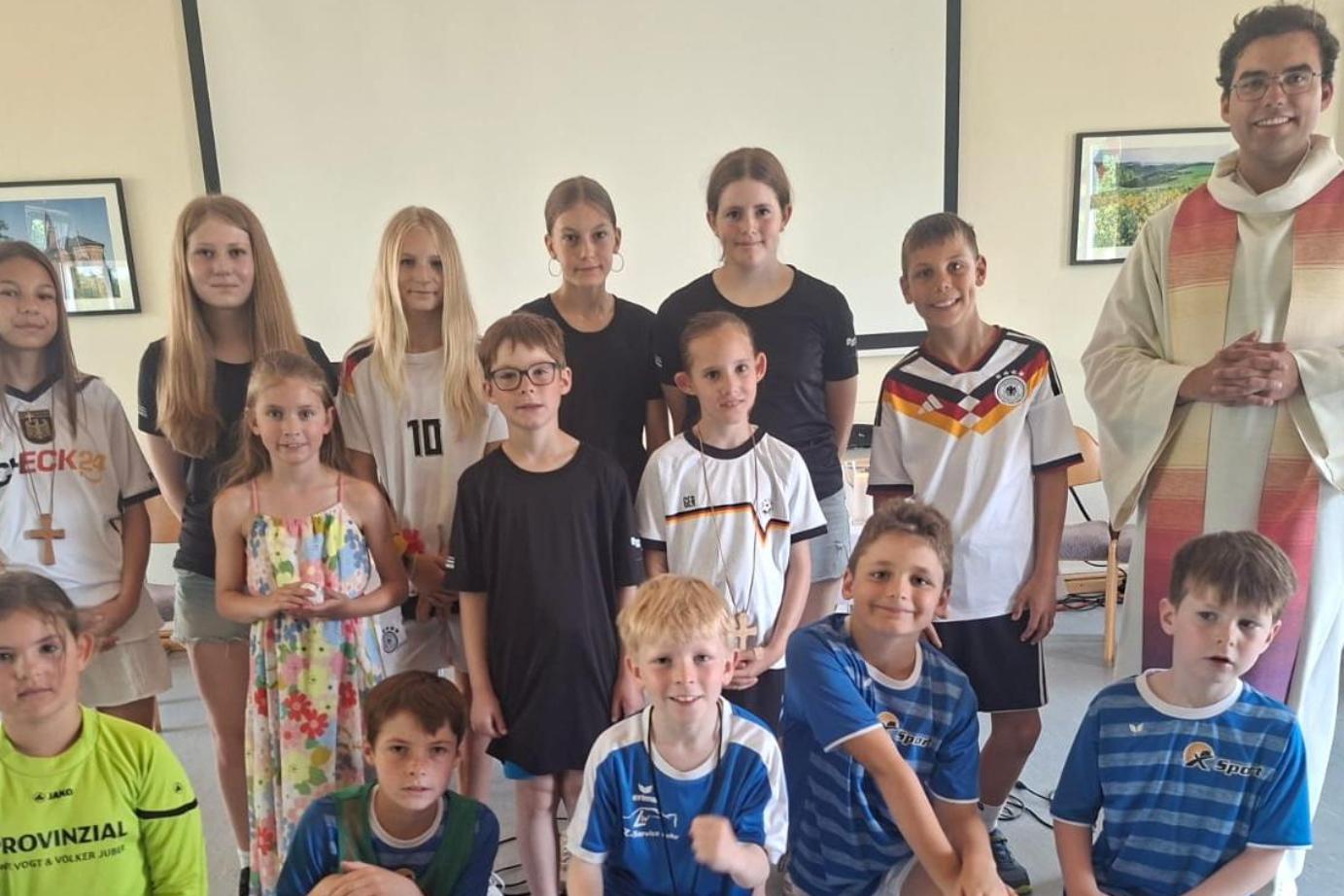 Priester mit zahlreichen Kindern in Sporttrikots