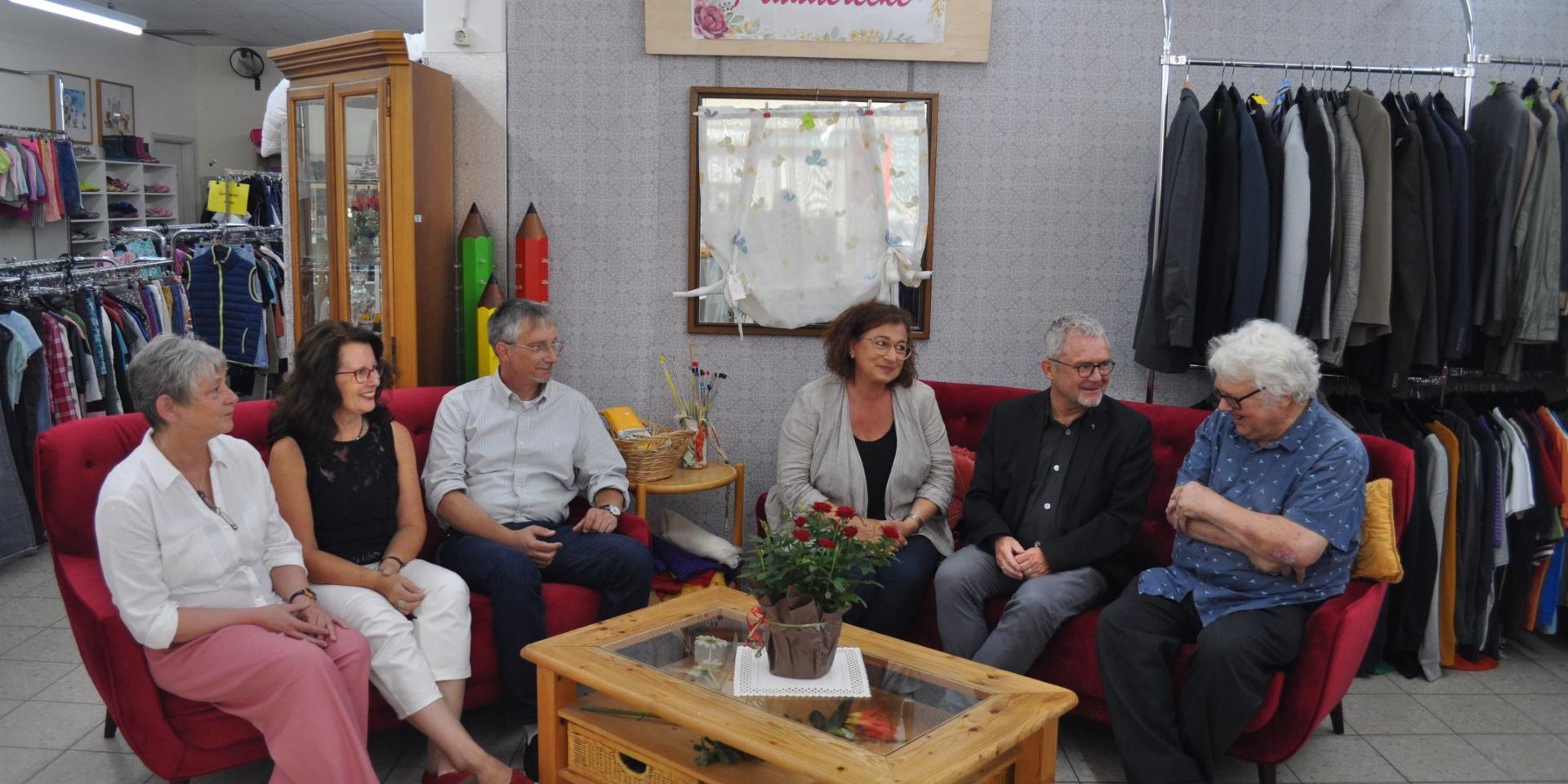 6 Menschen auf den roten Sofas im Caritas-Laden (c) Thomas Elsen Caritas 6 Menschen auf den roten Sofas im Caritas-Laden