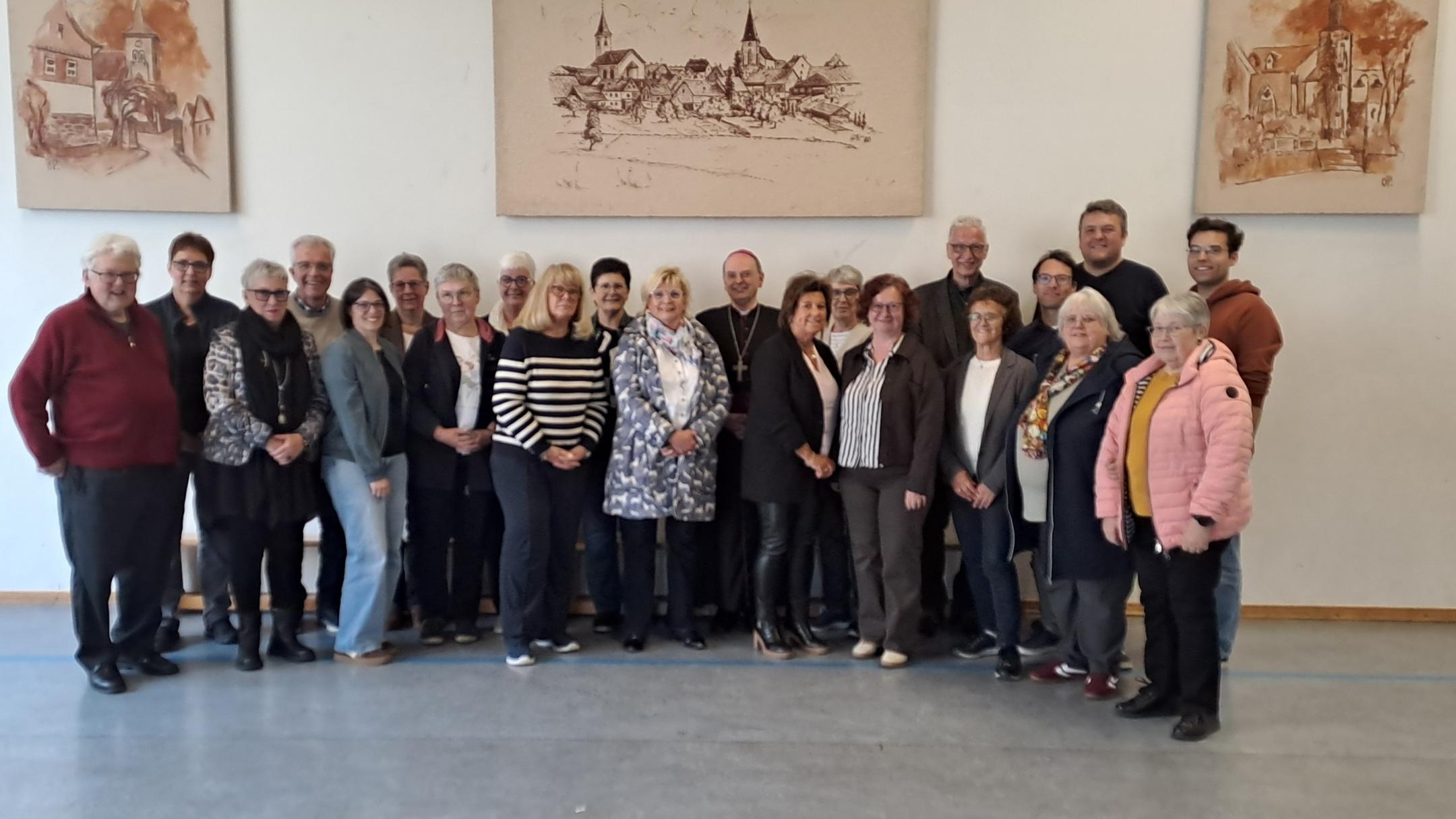 Gruppenfoto des Pfarrgemeinderates mit Gästen und einem Geistlichen in der Mitte im Gemeindehaus von Laubach.