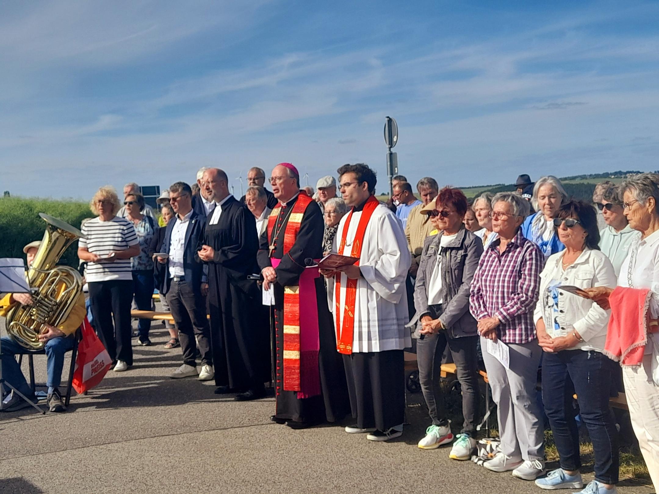 Geistliche und weitere Personen stehend im Freien beim Gebet (c) Barbara Wagner Geistliche und weitere Personen stehend im Freien beim Gebet
