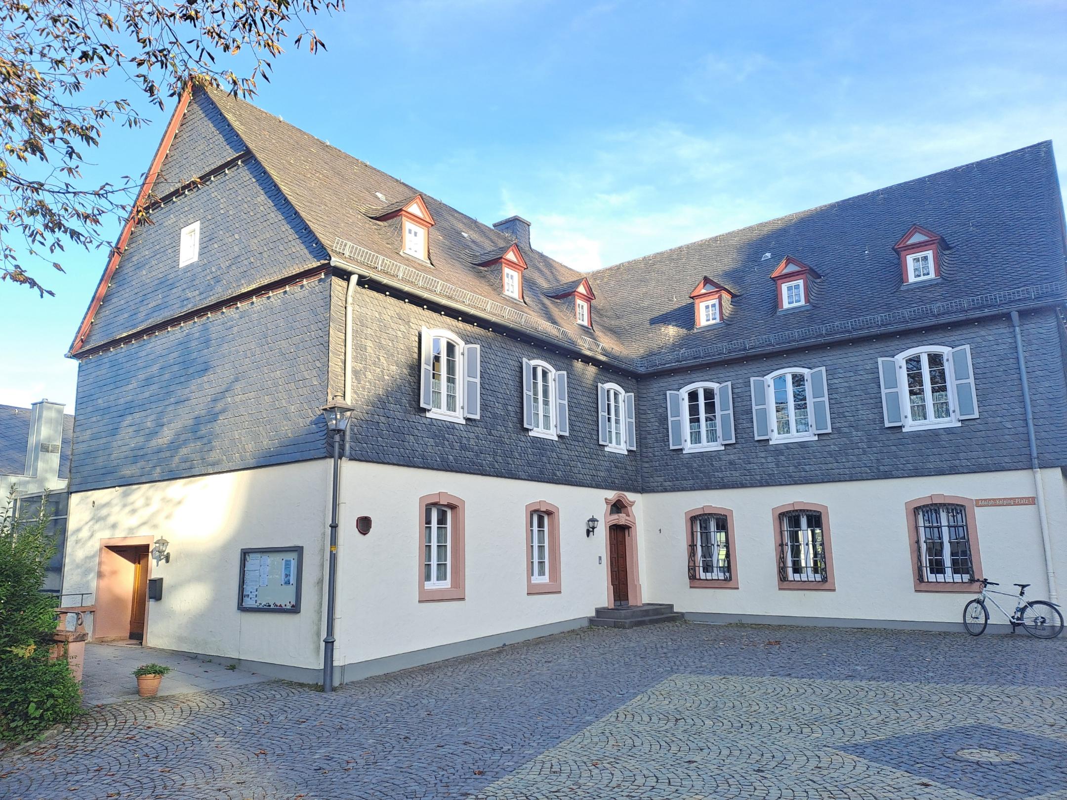 Historisches Pfarrhaus in Kastellaun mit Schieferfassade und Innenhof.
