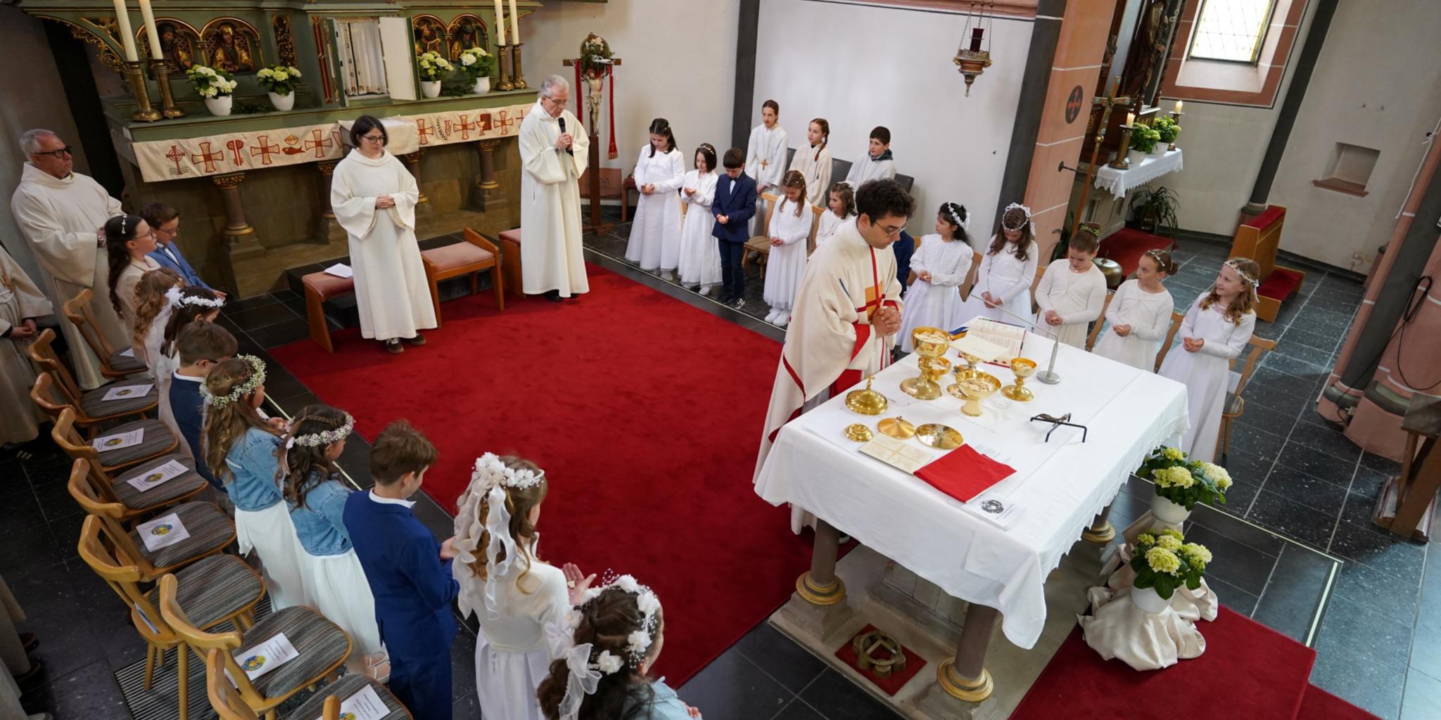 Erstkommunion_Kastellaun Kinder empfangen im Altarraum die erste heilige Kommunion.