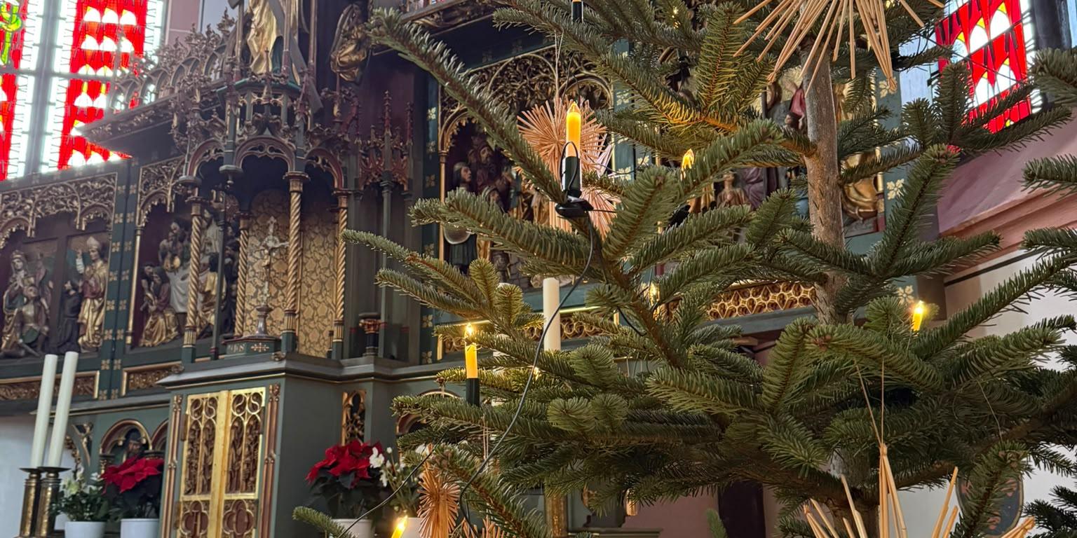 Weihnachten in der Pfarrkirche Ein geschmückter Weihnachtsbaum steht in der Kirche in Kastellaun. Im Hintergrund sieht man den Hochaltar.