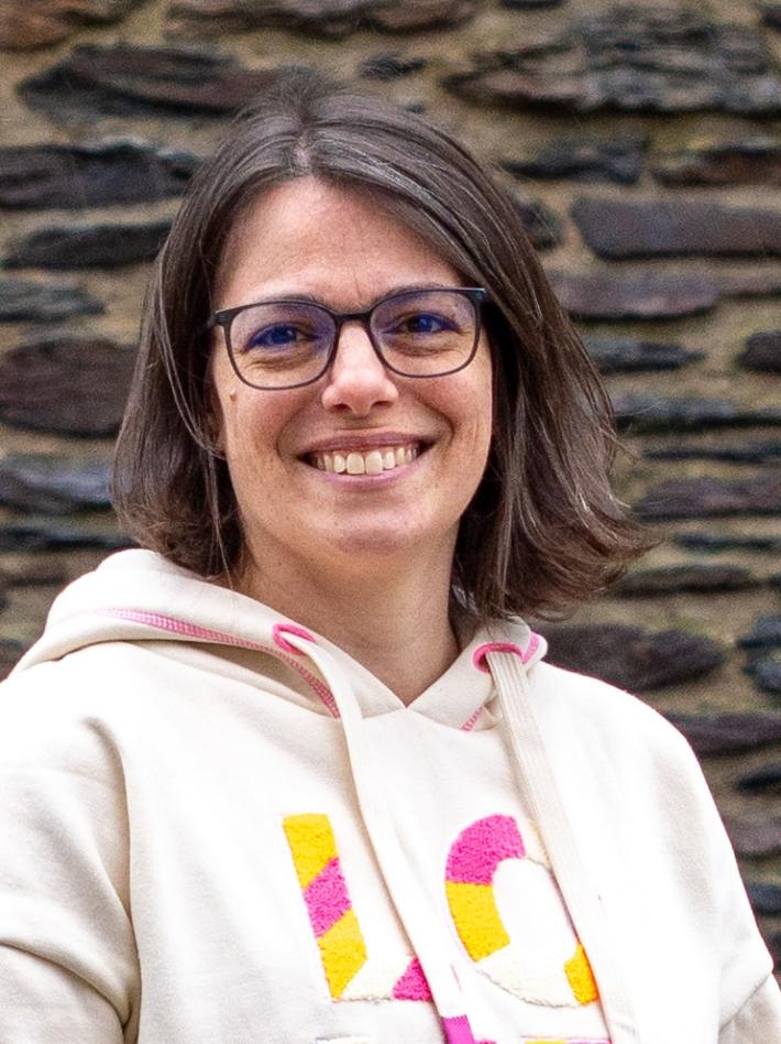 junge Frau mit kinnlangem dunklem Haar und dunkler Brille