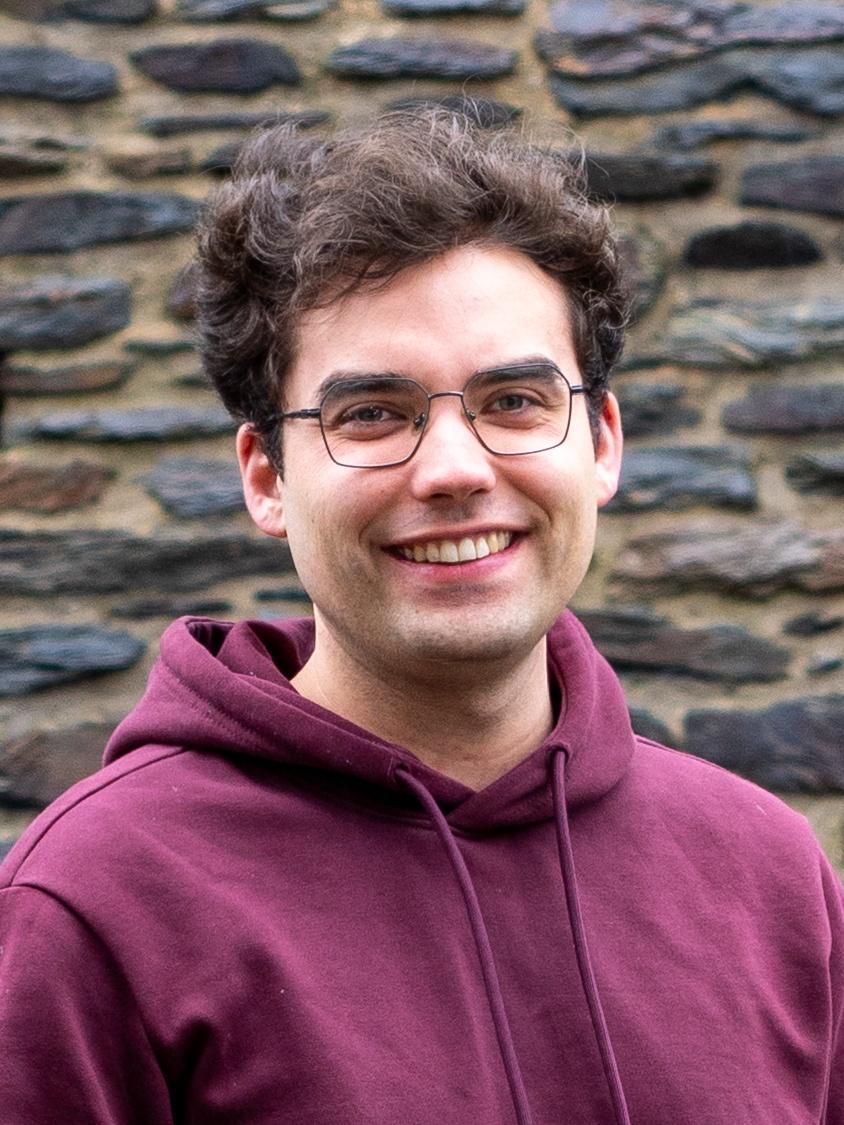 Junger Mann mit duklem Haar und dunkler Brille